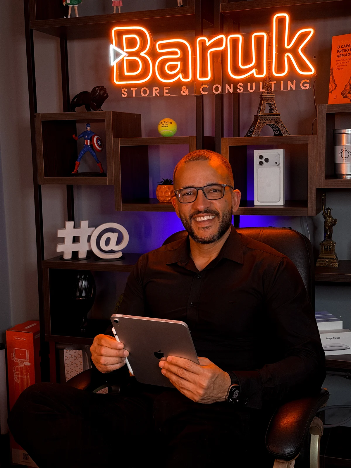 Vitor Rix, fundador da Baruk Store & Consulting, sorrindo com um iPad em mãos